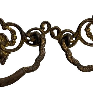 Può includere: Un paio di tiretti per cassetti in metallo dorato decorato con un motivo a conchiglia. I tiretti hanno una forma ad anello e sono progettati per l'uso su mobili.