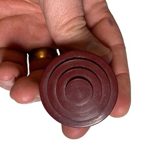 May include: A red wooden ring toss game piece with three concentric circles.