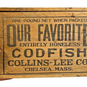 May include: Aged wooden box with black lettering that reads "OUR FAVORITE ENTIRELY BONELESS CODFISH". The box also features the text "ONE POUND NET WHEN PACKED" and "COLLINS-LEE CO. CHELSEA, MASS."