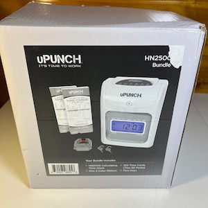 May include: A white box with the text "UPUNCH IT'S TIME TO WORK" and "HN2500 Bundle". The box contains a time clock, time cards, a two-color ribbon, and two keys. The time clock displays "12:03".