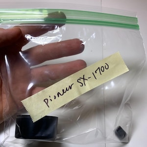May include: A clear plastic bag with a yellow sticky note that says "Pioneer SX-1700". Inside the bag are two black plastic pieces.