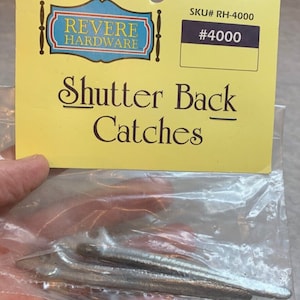 May include: A package of three silver shutter back catches. The package is labeled "Revere Hardware" and "Shutter Back Catches". The SKU number is RH-4000 and the item number is #4000.