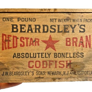 May include: A vintage wooden box with the text "BEARDSLEY'S RED STAR BRAND ABSOLUTELY BONELESS CODFISH." The box is labeled "ONE POUND" and includes the company's name and locations. The text is in red and black.