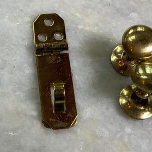 May include: A set of four gold-toned door knobs with a latch and screws.