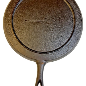 May include: A cast iron skillet with a round cooking surface and a handle with a hole for hanging. The skillet is dark brown and has a textured surface. The skillet measures approximately 8 inches in diameter.