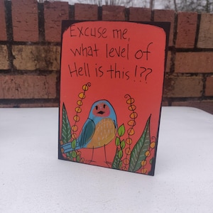 Puede incluir: Un fondo rojo con texto negro que dice "Disculpe, ¿qué nivel de infierno es este? !" Un pájaro azul con detalles amarillos está parado en una hoja verde con flores amarillas.