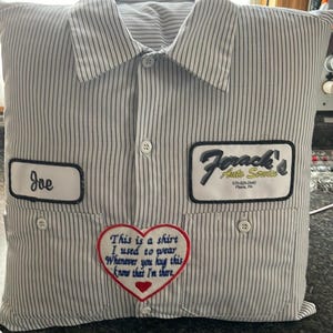 May include: Pillow shaped like a button-down shirt with vertical stripes. Features a patch that says "Joe" and another that says "Forack's Auto Service." A heart-shaped patch reads "This is a shirt I used to wear..."