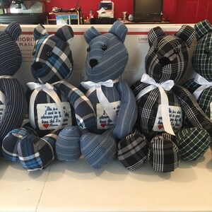 May include: Five handmade teddy bears made from repurposed plaid shirts. Each bear has a white ribbon around its neck and a small embroidered tag that reads "This is a shirt I used to wear, whenever you hug it know that I'm here. Love."