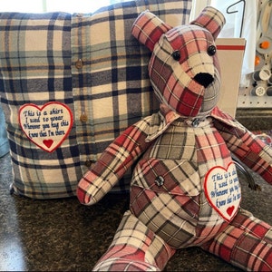 May include: A square plaid pillow and a stuffed bear made from plaid fabric. Both items feature a white heart-shaped patch with red trim and the embroidered text: This is a shirt I used to wear. Whenever you hug this, know that I'm there.