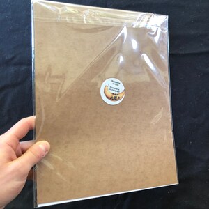 May include: A brown paper print with a round sticker on the bottom right corner. The sticker has a banana with black seeds and the text "Drawesome on Etsy" and "@drawesome on Instagram".