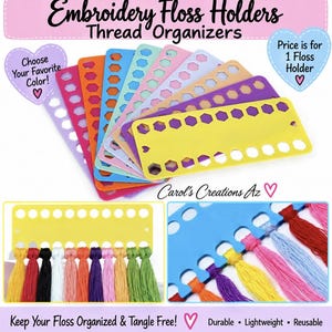 May include: A collection of colorful plastic embroidery floss holders and thread organizers in shades of yellow, purple, blue, pink, and orange. Each rectangular organizer features a row of circular holes for winding thread and a heart-shaped cutout.