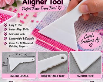 May include: A white plastic diamond painting aligner tool with a triangular head and a handle featuring a finger grip and a hole. The tool measures 4.7 inches by 2.4 inches. Text includes Diamond Painting Aligner Tool, Carol's Creations Az.