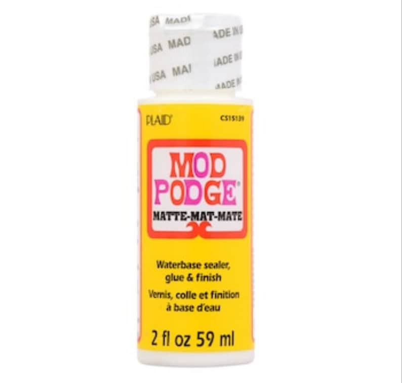 May include: A bottle of Mod Podge Matte-Matte-Mate waterbase sealer, glue, and finish. The bottle is yellow with a red and pink logo and white text. It contains 2 fl oz, equivalent to 59 ml.