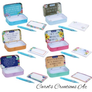 May include: Set of six colorful metal tins with inspirational quotes and scripture verses. Each tin includes a small notepad and a pencil. The tins are decorated with floral patterns.