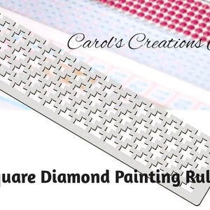 May include: A white plastic ruler with a grid pattern for square diamond painting. The ruler is labeled "Square Diamond Painting Ruler" and "Carol's Creations Az".
