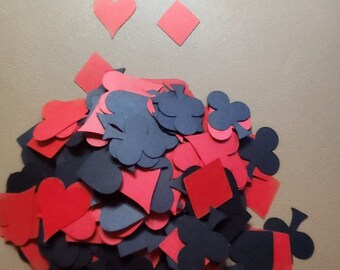 May include: A pile of red and black card suit shapes, including hearts, diamonds, clubs, and spades. The shapes are made of paper and are scattered on a light brown surface. The text "Carol's Creations Az" is visible at the bottom of the image.