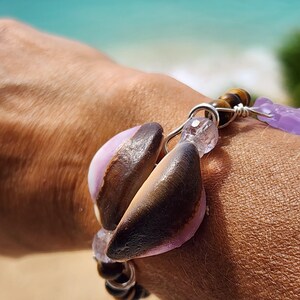 May include: A brown and purple seed pod bracelet with tiger's eye beads and amethyst stones.
