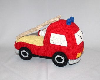 May include: A red crocheted fire truck toy with a yellow bed, white windows, and a beige ladder. The truck has black wheels with white details and blue sirens on top.