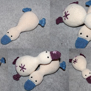 Peut inclure: Cinq peluches de canard en crochet dans différentes poses. Les canards sont beiges avec des accents violets et bleus. Chaque canard a une fleur brodée sur sa poitrine.