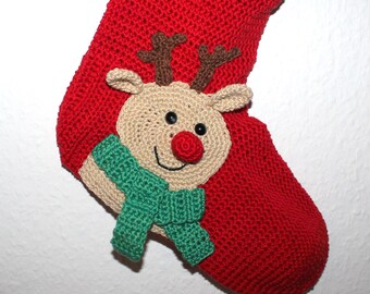 May include: Red crocheted Christmas stocking with a reindeer face and green scarf. The reindeer has a brown nose and black eyes.