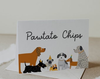 May include: A white card with the text "Pawtato Chips" in black script. The card features a colorful illustration of seven dogs wearing party hats. The dogs are a brown and white spaniel, a black and white terrier, a pug, a grey and white poodle, a black and white terrier, a dachshund, and a dalmatian.