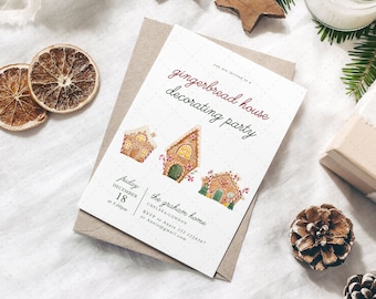 Puede incluir: Una invitación festiva para una fiesta de decoración de casas de jengibre. La invitación presenta ilustraciones de acuarela de casas de jengibre e incluye detalles del evento. Decorado con estrellas de madera, agujas de pino y una caja de regalo.