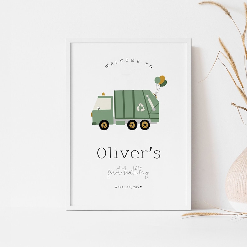K&ouml;nnte beinhalten: Gerahmter Druck mit einer Illustration eines gr&uuml;nen M&uuml;llwagens, Luftballons und dem Text "WELCOME TO" &uuml;ber "Oliver's first birthday" und dem Datum. Der LKW hat schwarze R&auml;der und ein Recycling-Symbol.