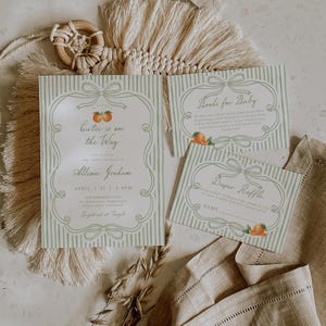 Può includere: Un set di inviti per baby shower con sfondo a righe verde chiaro, bordo a nastro decorativo e illustrazioni di arance. Il testo include A Little Cutie is on the Way, Books for Baby e Diaper Raffle con i dettagli dell'evento.