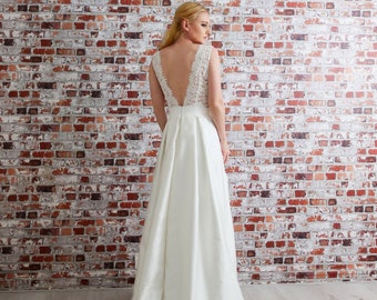 Robe de mariée longue en dentelle, style princesse avec traîne. Décolleté et dos nu en dentelle. Jupe à plis mariage luxe