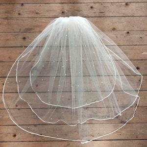 Velo de novia de largo medio en tul y perlas. Accesorio de boda. Peinado de novia