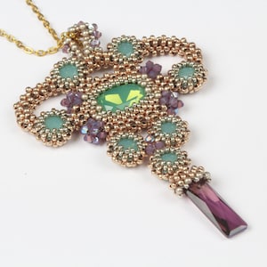 May include: A gold chain necklace with a beaded pendant featuring a green gemstone surrounded by smaller green, purple, and gold beads.