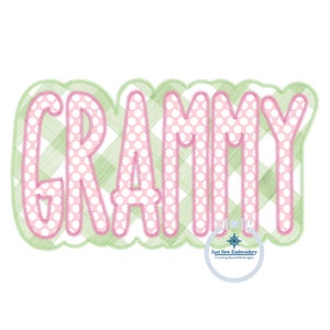 May include: A pink and green embroidered design of the word "GRAMMY" with a white polka dot pattern. The design is surrounded by a green stitched border.