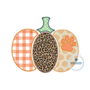 May include: A patchwork pumpkin with a gingham, leopard print, and polka dot design. The pumpkin has a paw print on the side.