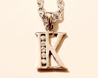 A silver initial "K" with 5 cubic zirconia necklace