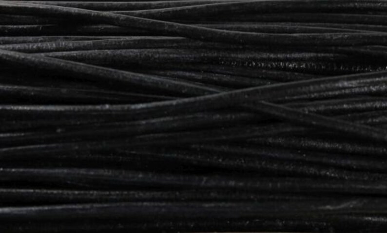 May include: A close-up of black leather cord, showing the texture and detail of the material.