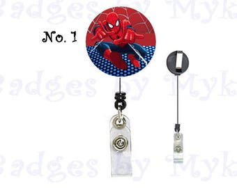 May include: A red and blue retractable badge holder with a cartoon image of Spiderman on the front. The text "No. 1" is printed on the image.