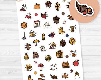 May include: A sheet of colorful fall-themed stickers featuring pumpkins, leaves, acorns, and other autumn icons. The stickers include a variety of illustrations, such as a turkey, a cup of tea, and a sweater. The sheet is labeled "Orange Umbrella Co."
