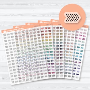 May include: Sheets of arrow-shaped stickers in various colors, including red, green, blue, and purple. Each sheet is labeled with a code and the Orange Umbrella Co. logo. A sticker with a black arrow design is also visible.