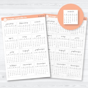 May include: Sheets of calendar stickers with months from January to December, featuring a simple, handwritten font. The stickers are in a light peach color with a small orange logo.