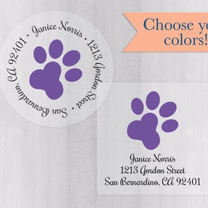 Può includere: Due etichette trasparenti con un design a zampa viola. Una è rotonda, l'altra quadrata. Entrambe includono il testo "Janice Norris, 1213 Gordon Street, San Bernardino, CA 92401". È presente anche il testo "Scegli i tuoi colori!"