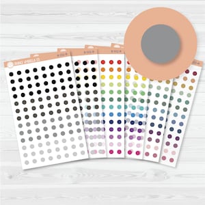 May include: A selection of dot sticker sheets in a range of colours, from black to grey and a rainbow of hues. The sheets are fanned out, with the brand name "ORANGE UMBRELLA CO" visible on one. Ideal for planners and crafts.
