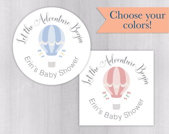 May include: Two baby shower stickers, one round and one square, feature a hot air balloon design. The round sticker has a blue balloon, while the square sticker has a pink balloon. Both stickers have the text "Let the Adventure Begin" and "Erin's Baby Shower".