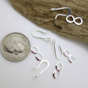 May include: Silver-toned jewelry findings, including a set of 5 jump rings and 5 lobster claw clasps. The findings are shown next to a US dime for scale.