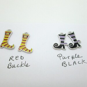 May include: Two pairs of witch boot charms. One pair is yellow and red with a black buckle. The other pair is black with purple stripes. The text "Red Buckle" and "Purple Black" is written below each pair.