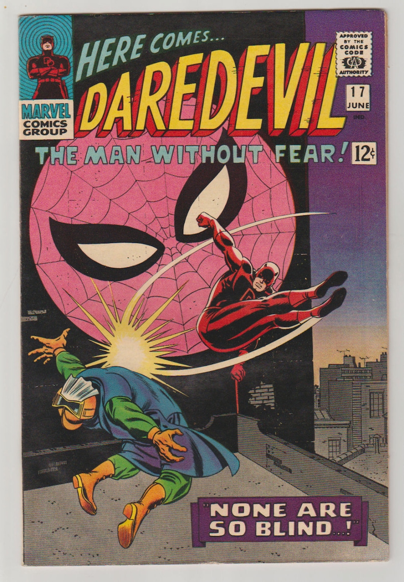 K&ouml;nnte beinhalten: Vintage Comic-Cover mit Daredevil in einer dynamischen Actionpose. Das Cover hat einen rosa Spinnennetz-Hintergrund mit dem Titel "DAREDEVIL" in gro&szlig;en gelben Buchstaben. Der Text "The Man Without Fear" ist ebenfalls sichtbar.