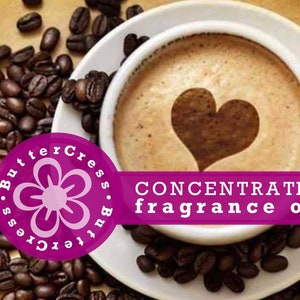 May include: A close-up of a cup of coffee with a heart design in the foam. The coffee is surrounded by coffee beans. The text "CONCENTRATED fragrance oil" is on a purple banner.