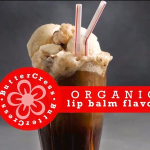 May include: A glass of root beer float with vanilla ice cream and two red straws. The glass is topped with whipped cream. A red circle with a pink flower and the text "ButterCress.ButterCress" is in the lower left corner. A red banner with the text "ORGANIC lip balm flavor" is at the top of the image.