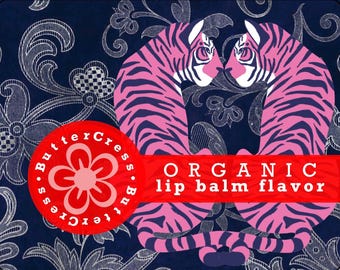 May include: An illustration of two pink and blue tigers facing each other on a dark blue background with a white floral pattern. The text "ButterCress.ButterCress" is in a circle with a pink flower in the centre. The text "ORGANIC lip balm flavour" is in a red banner.