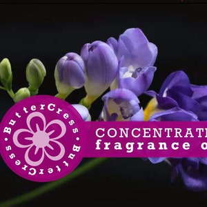 May include: Purple freesia flowers with a pink circle label that says "ButterCress. ButterCress." with a stylized flower inside the circle. The label also says "CONCENTRATED fragrance oil".