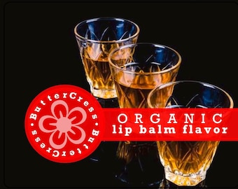 May include: Three clear glass shot glasses filled with a golden liquid. The glasses are on a black background with a red and white logo that says "ButterCress. ButterCress" and "ORGANIC lip balm flavour".